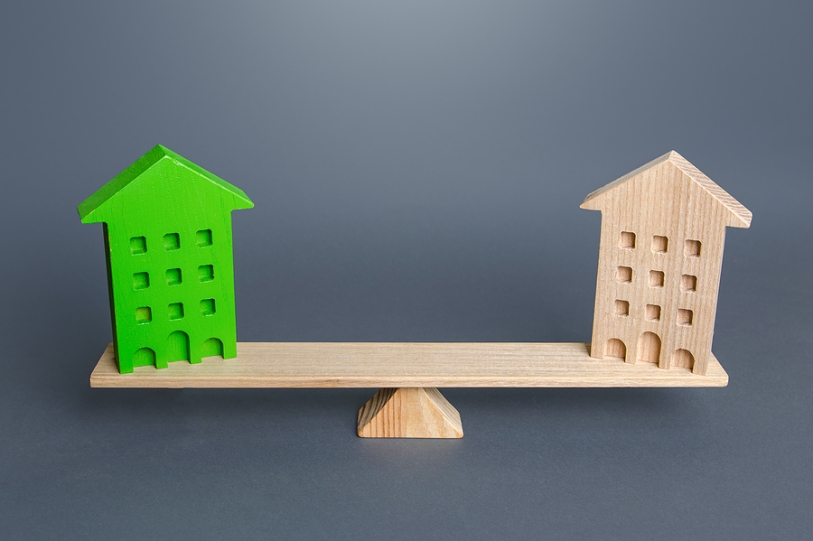 green model house balancing scales